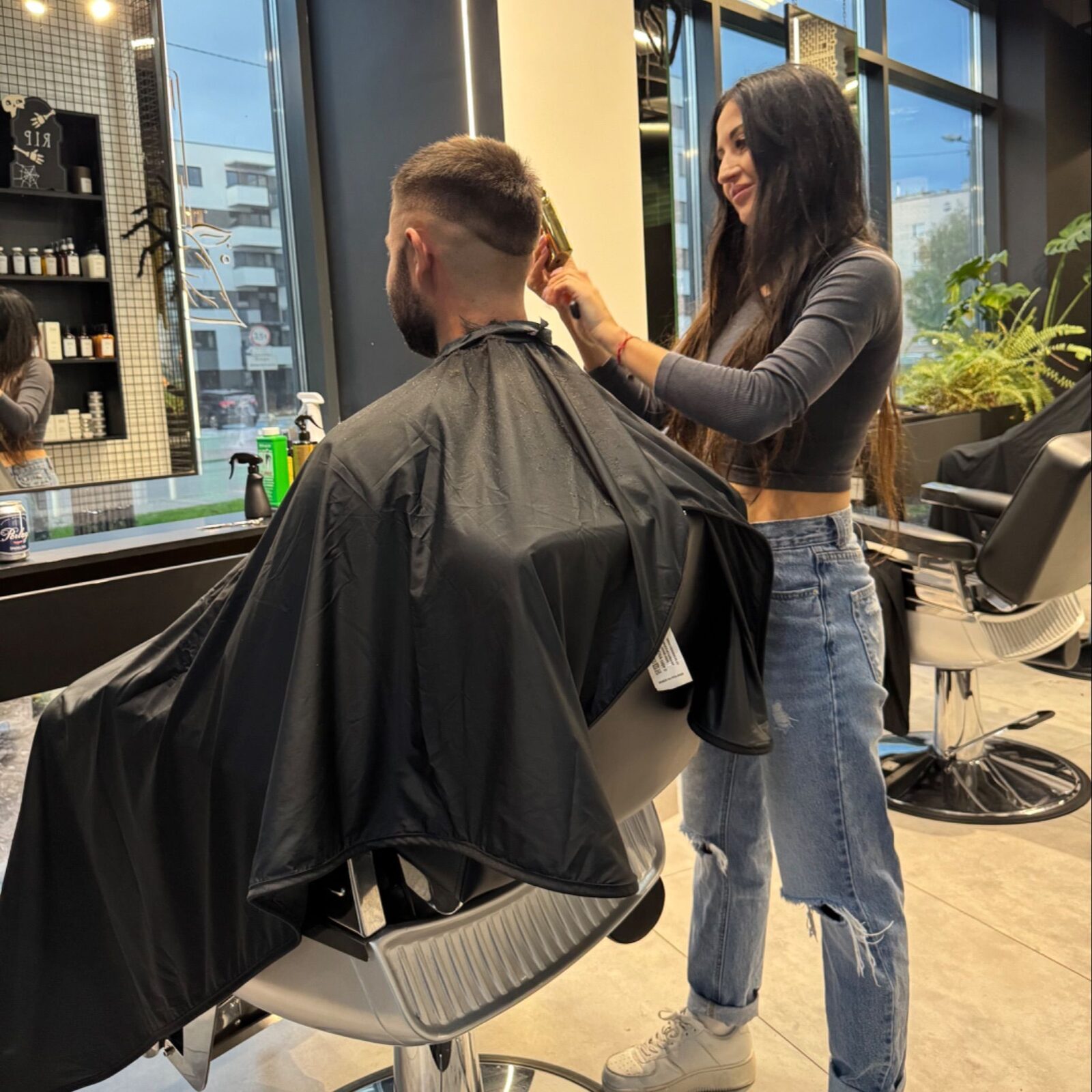 Barberka strzyże klienta w salonie Urban Jungle Barber